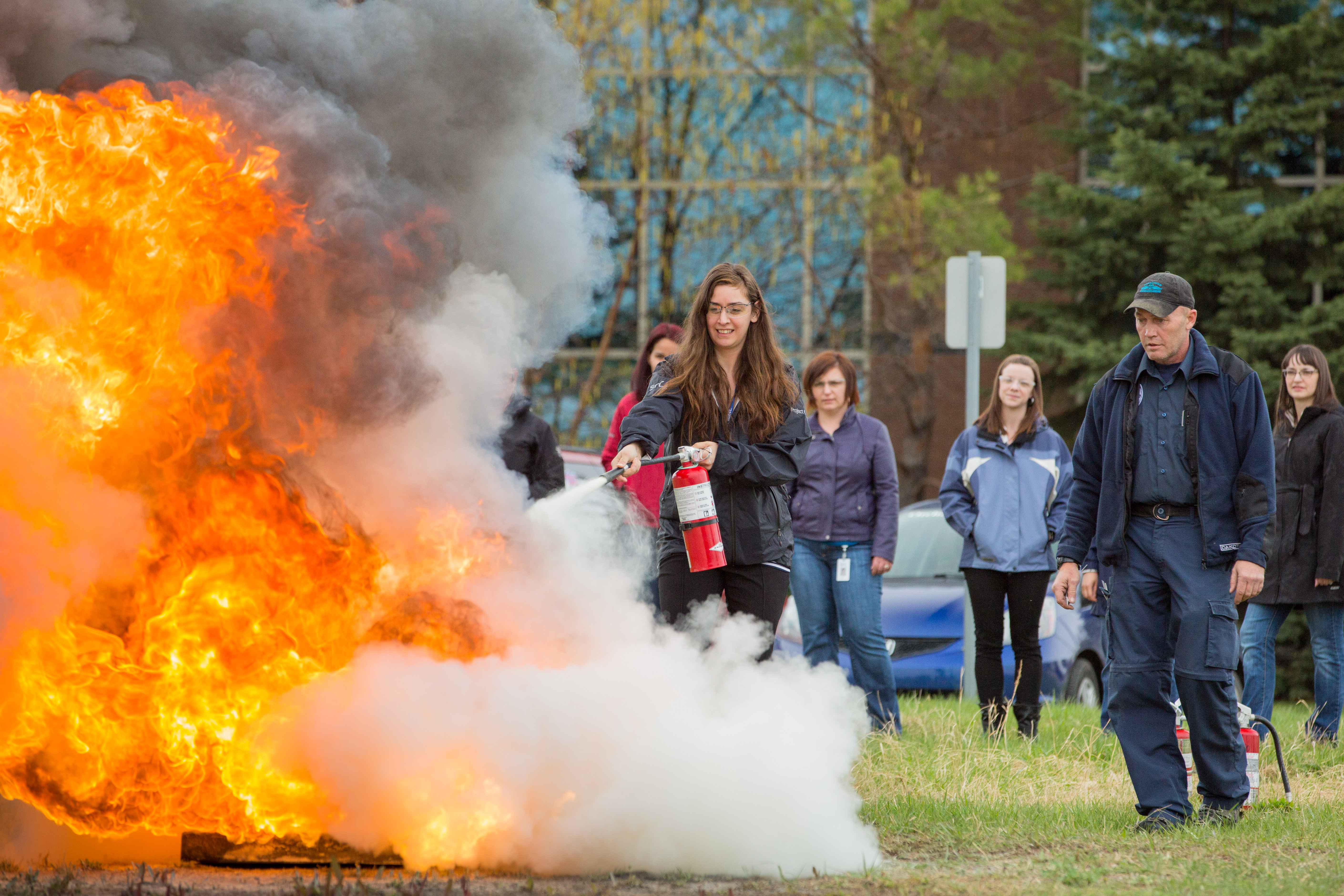 Woman extinguishes fire during fire extinguisher training