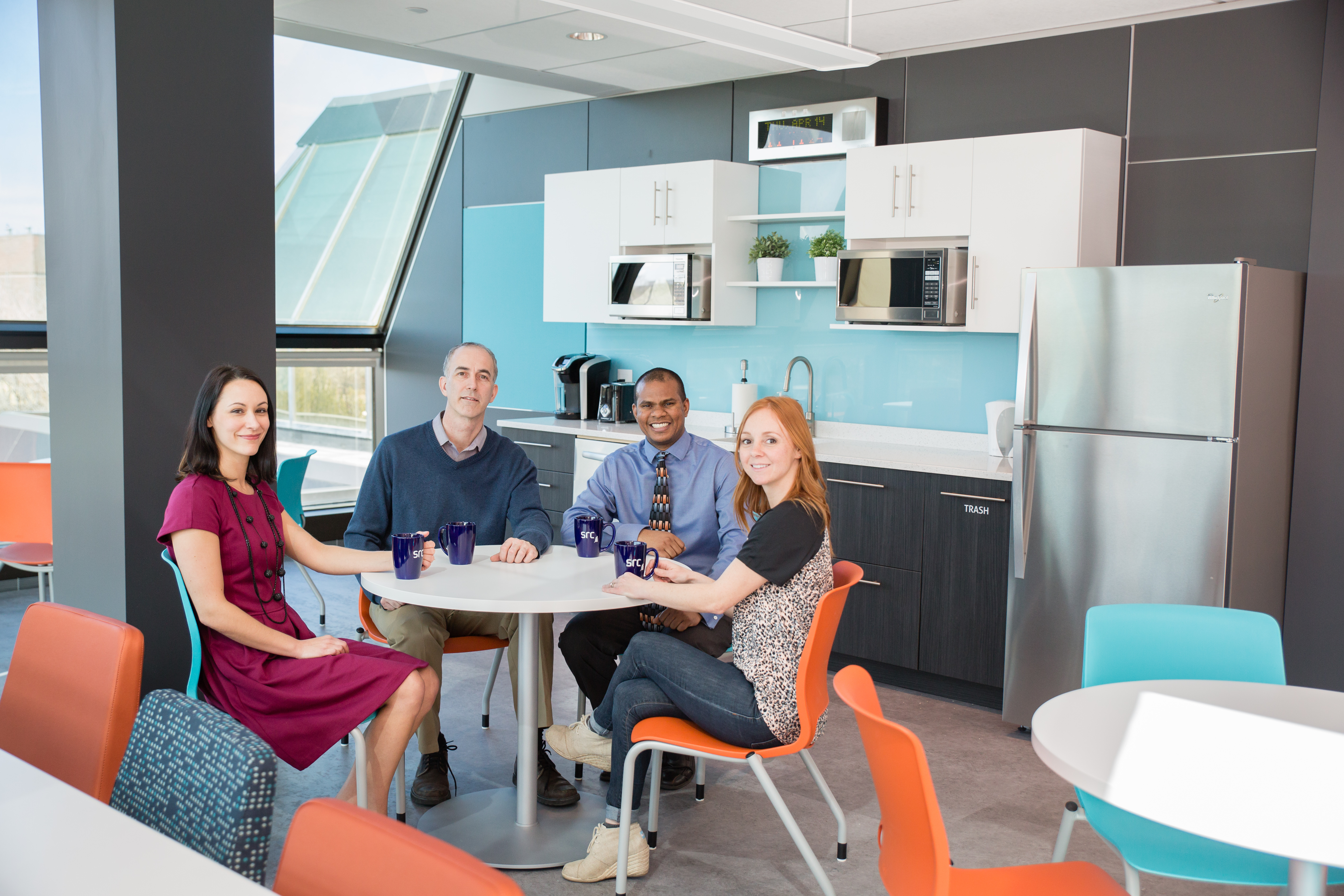 four employees sit in staff room