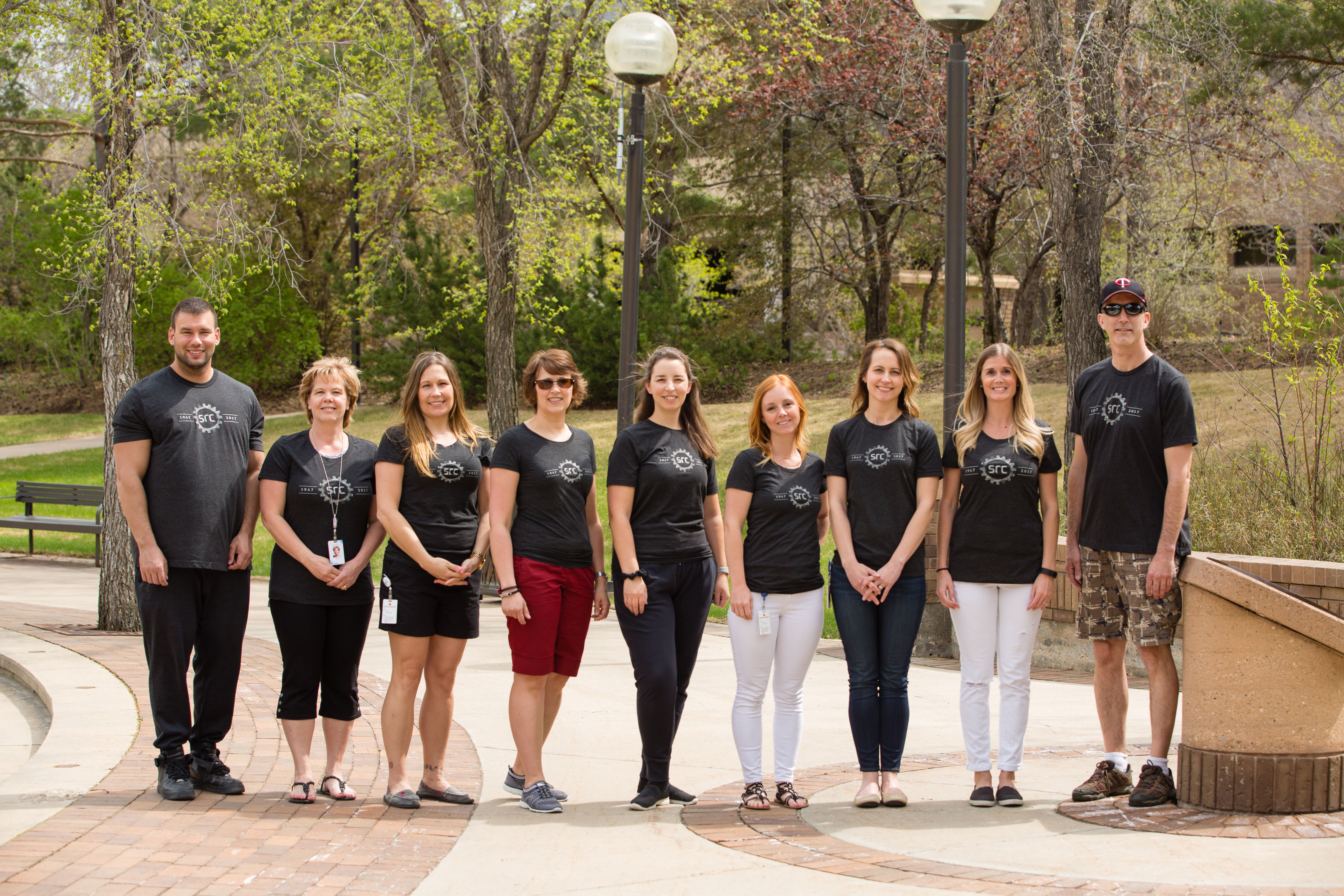 SRC employees stand outside wearing 70th t-shirts