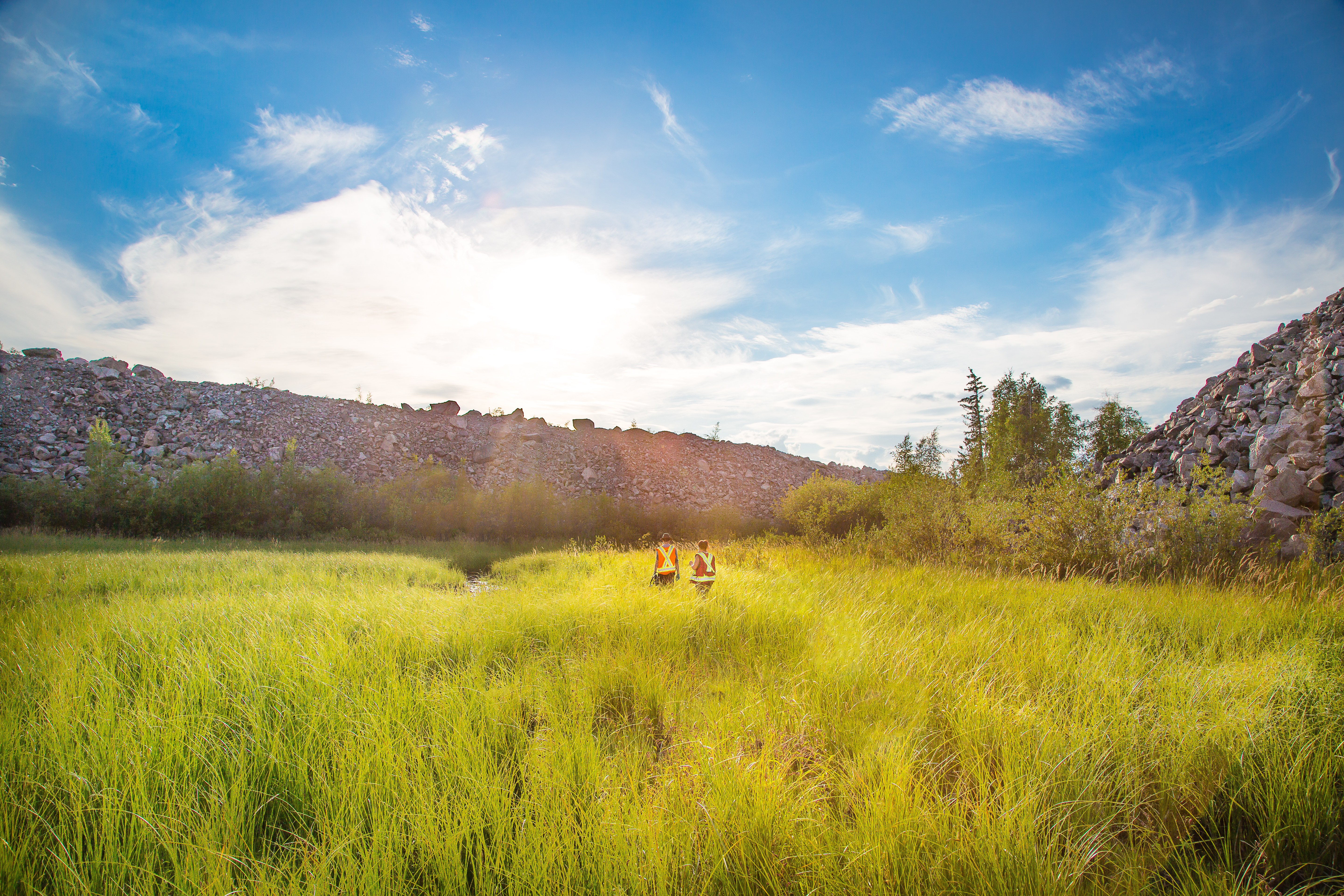 two field workers walk over field