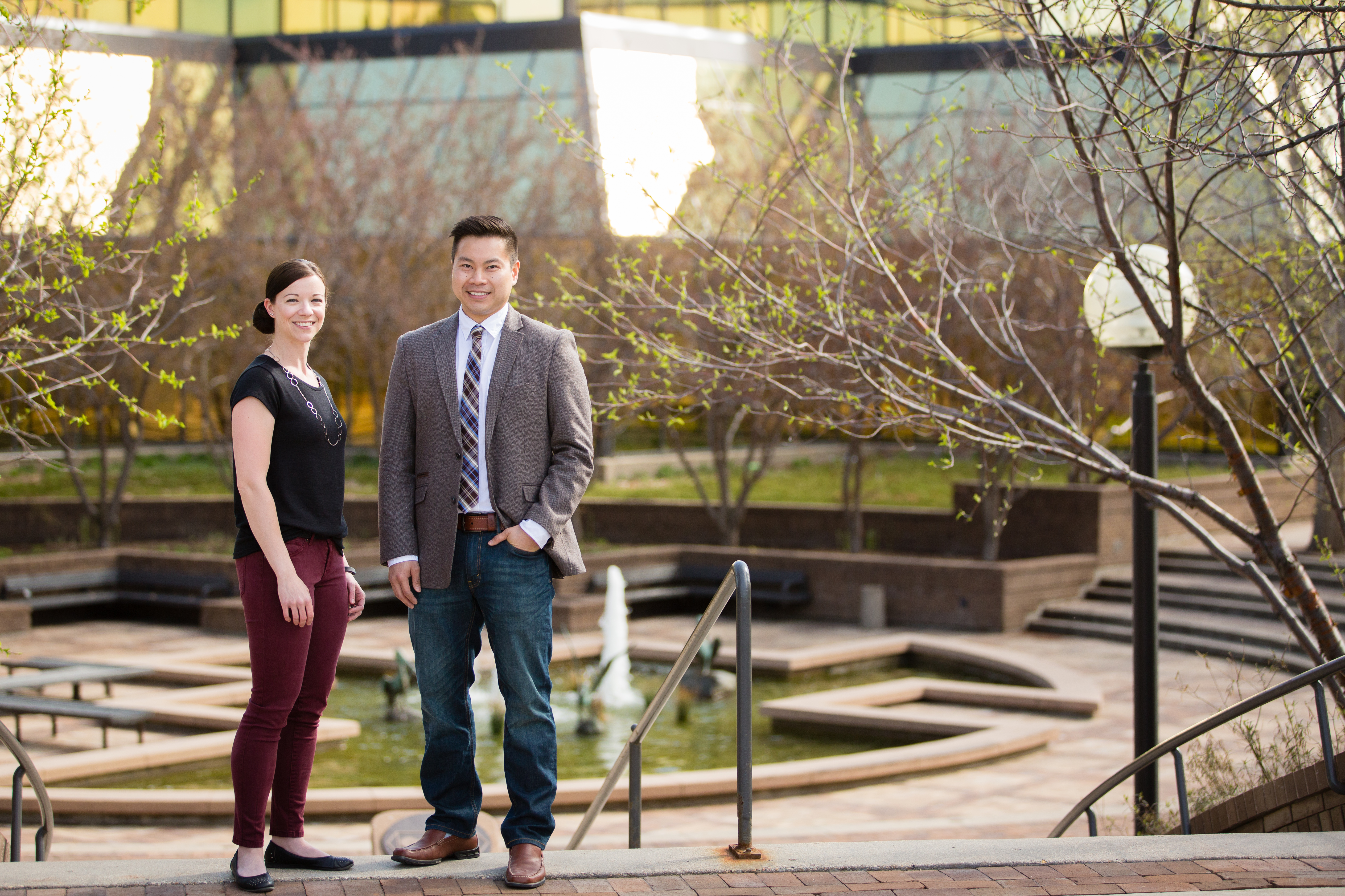 two professionals stand in front of glass building