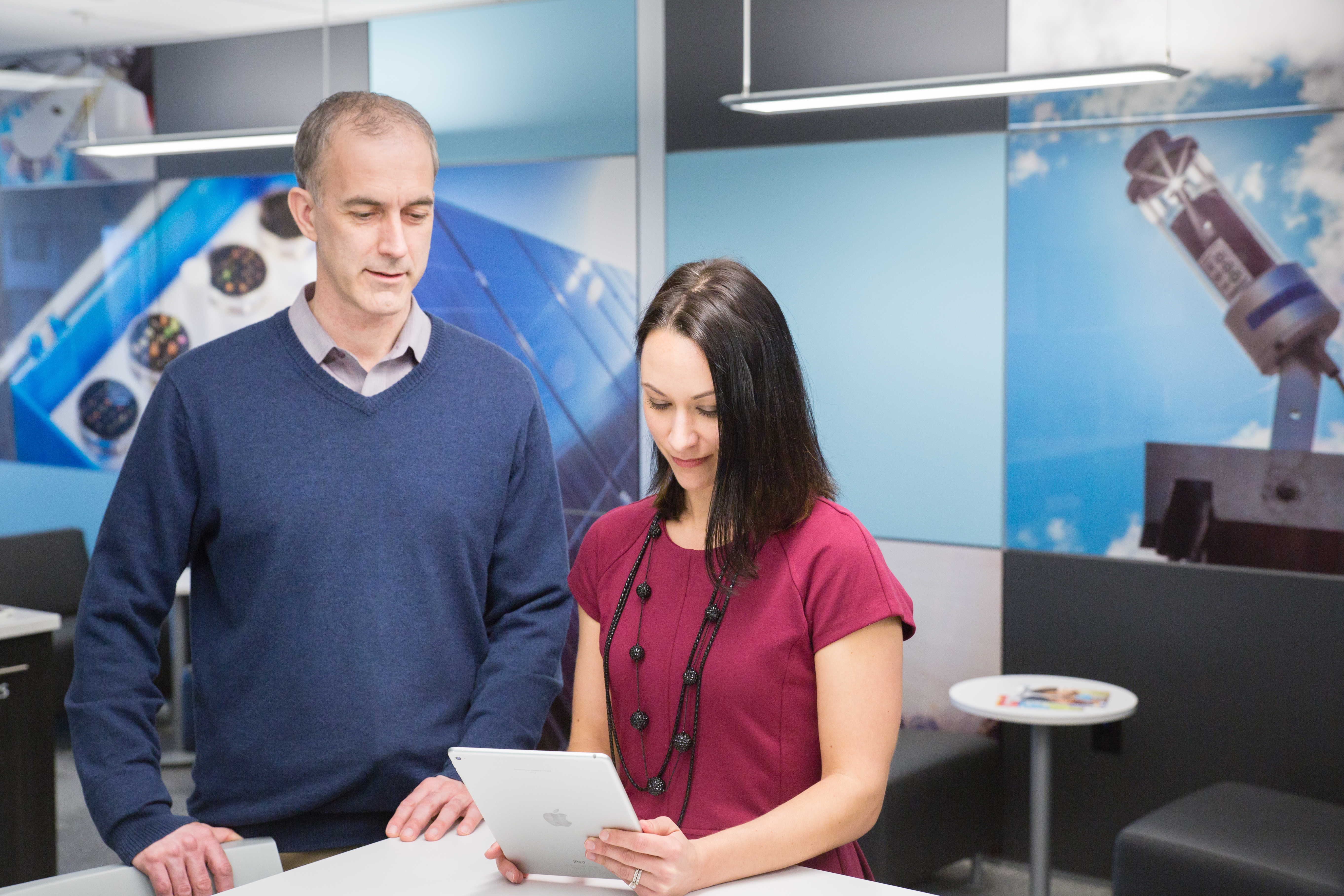 a man and a woman look at a piece of paper