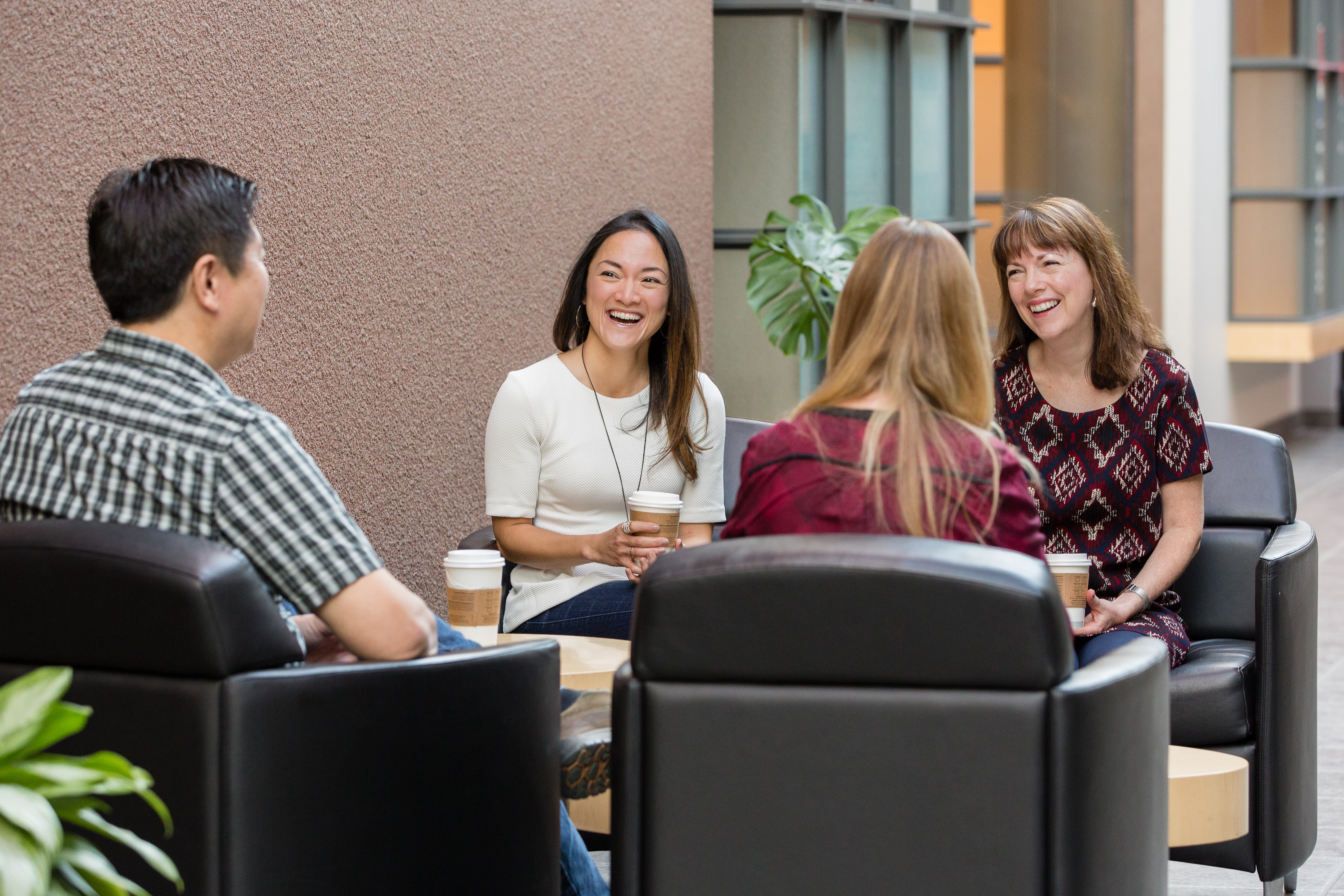 four employees sit in common area