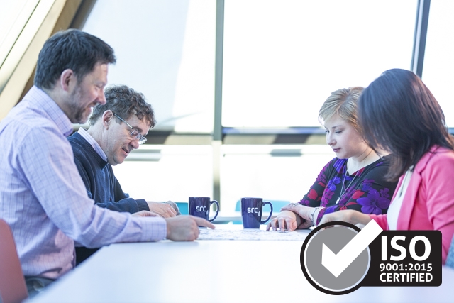 four src employees at a table and iso certification logo