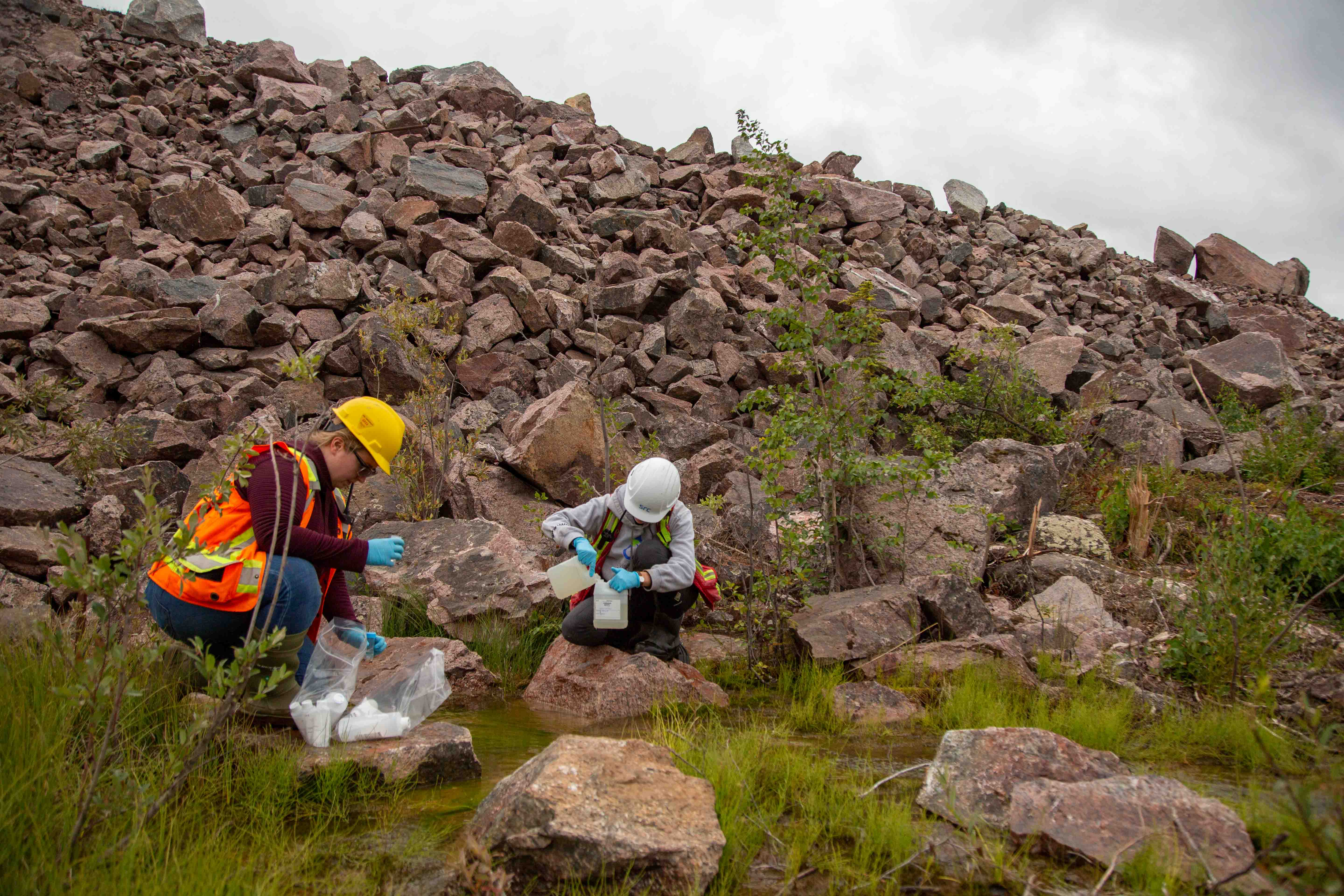 environmental remediation workers conduct water sampling