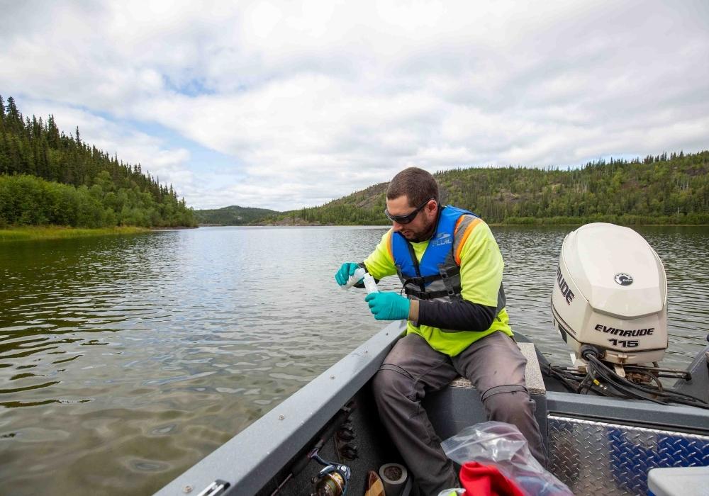 src scientist tests water at northern lake
