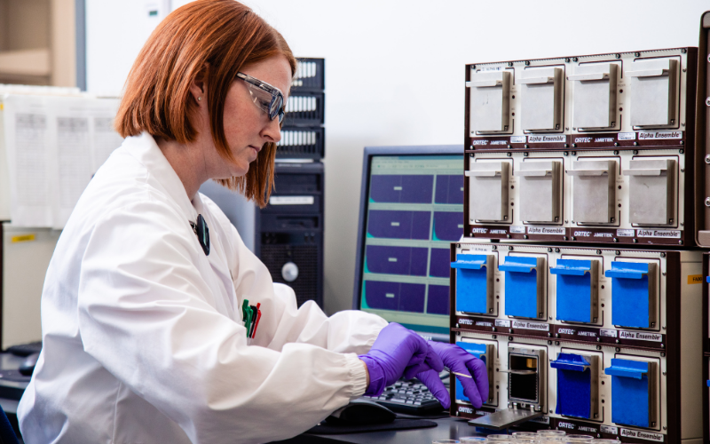 src employee analyzing radioactivity level of a sample in a lab