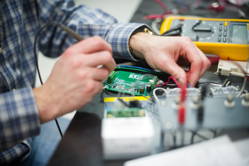 employee working on circuit board with sensors