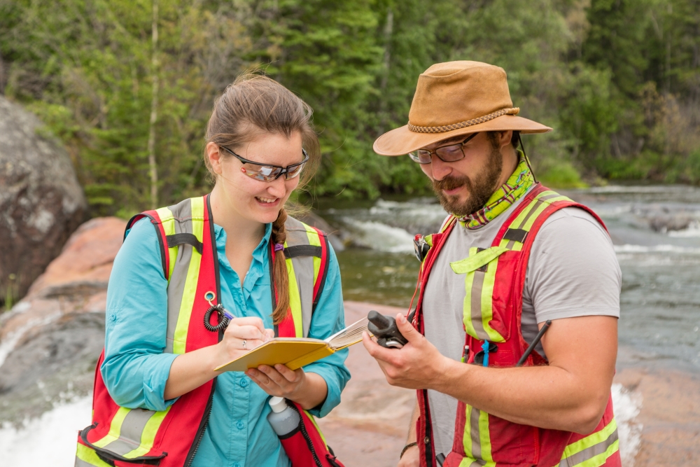 two field workers look at water sample