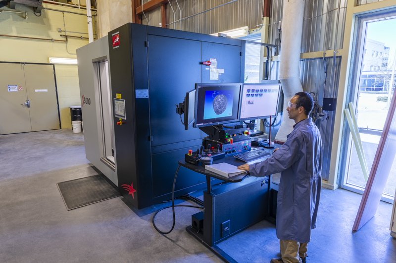 src research engineer operates industrial ct scanner in oil and gas lab