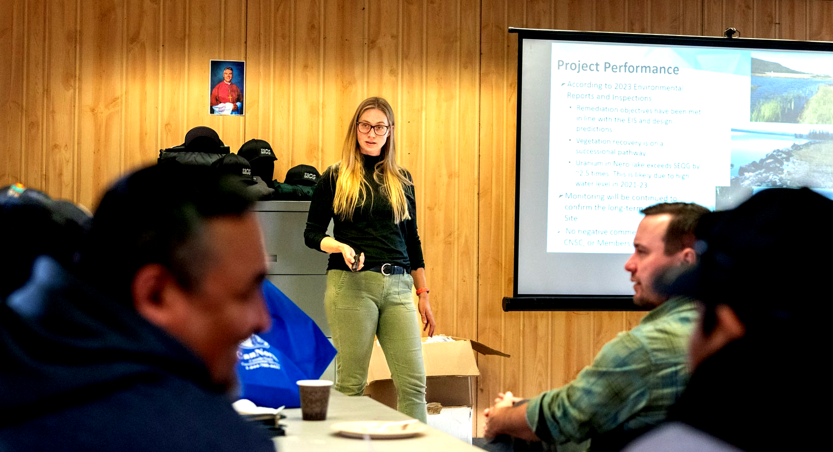 Skye Muirhead discusses project information with attendees at a community meeting