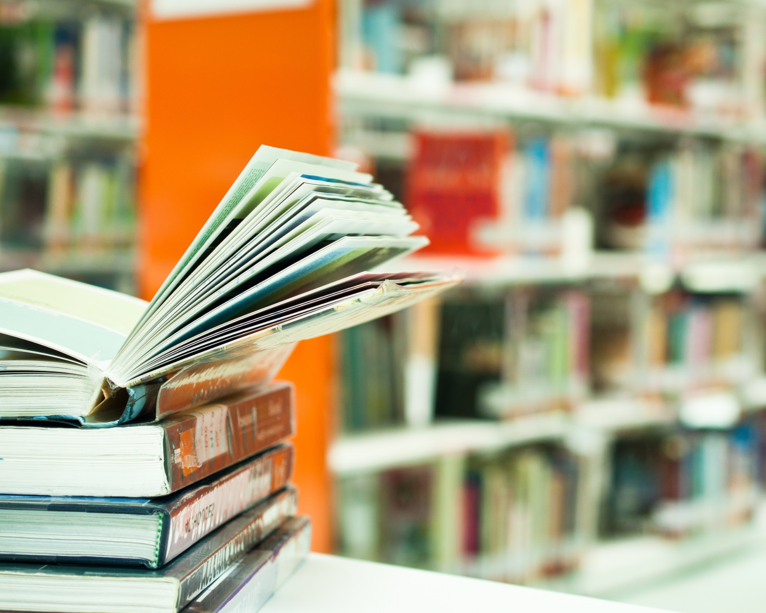 stack of books recommended by src in a library