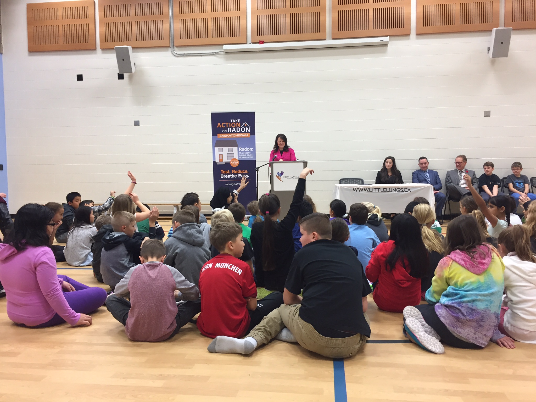 woman speaks to crowd of students with hands raised