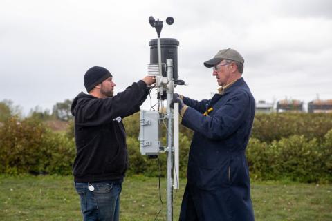 two engineers install solar panel at src weather station