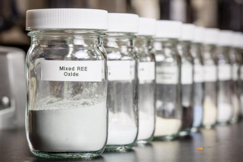 Row of glass jars filled with rare earths