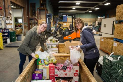 two female src employees volunteer at food bank