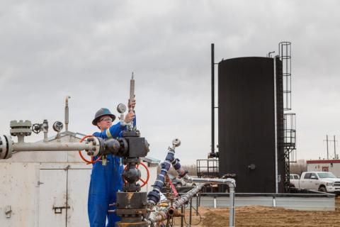 src technician inspects well head at oil site