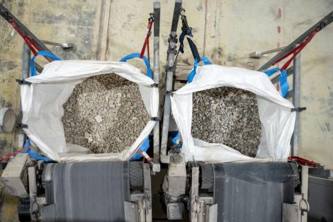 two bags of separate rock beneath two conveyor belts at src's sorting facility