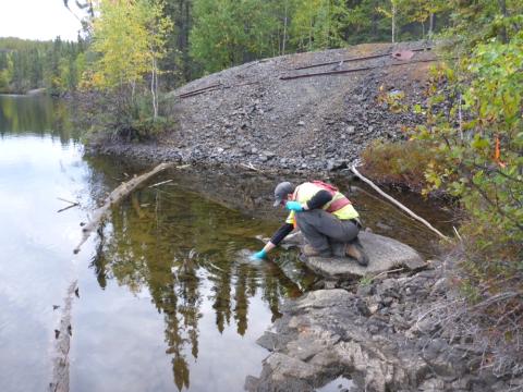 src remediation specialist collects water sample at lake