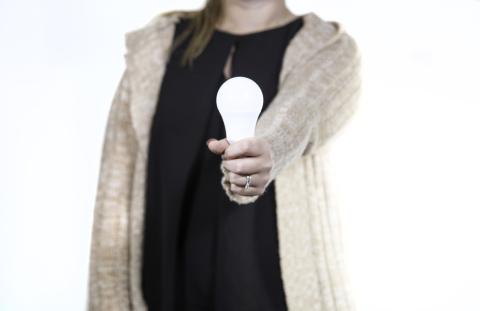 src female employee holding energy-efficient led lightbulb