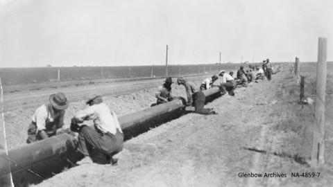 Laying pipe for pipeline between Turner Valley and Calgary, southern Alberta.