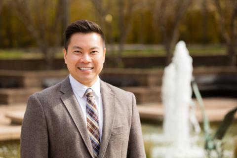 src employee stands in front of fountain