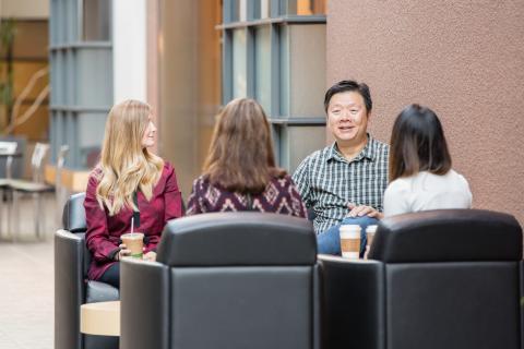 four people sitting down talking