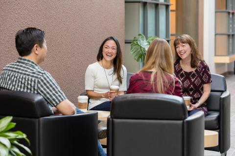 four employees sit in common area