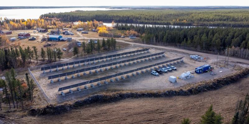 aerial photo of a northern lake community with a solar panel array and microgrid site