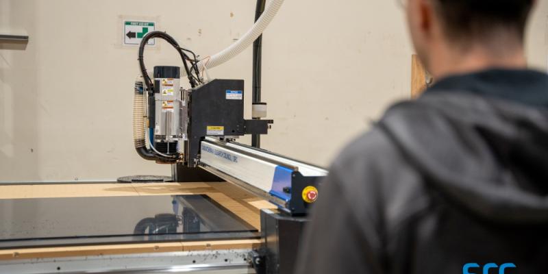 man supervises laser cutter at src