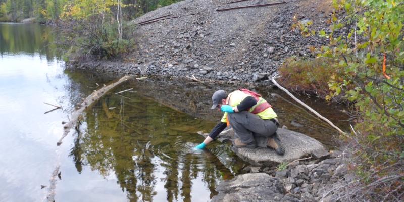 src remediation specialist collects water sample at lake