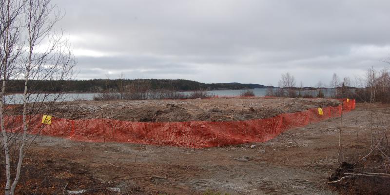 rough dirt hill surrounded by orange safety fence