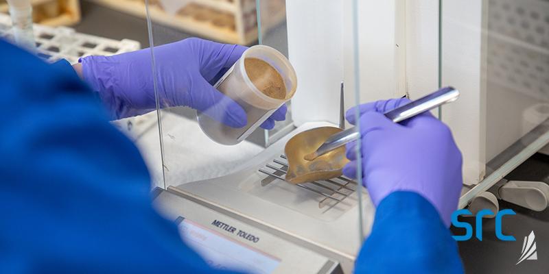 src technician weighs sample in lab