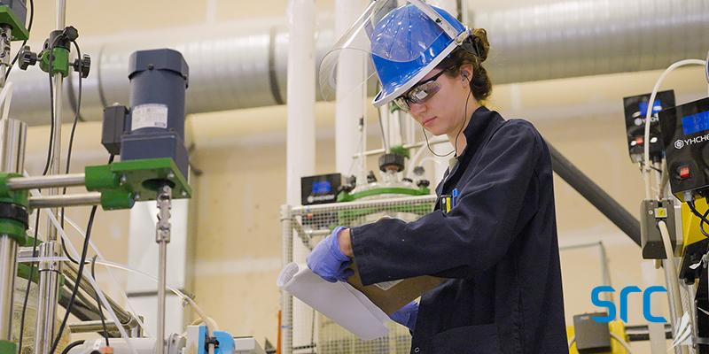 src technician writing on clipboard in lab