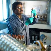 researcher examines vial